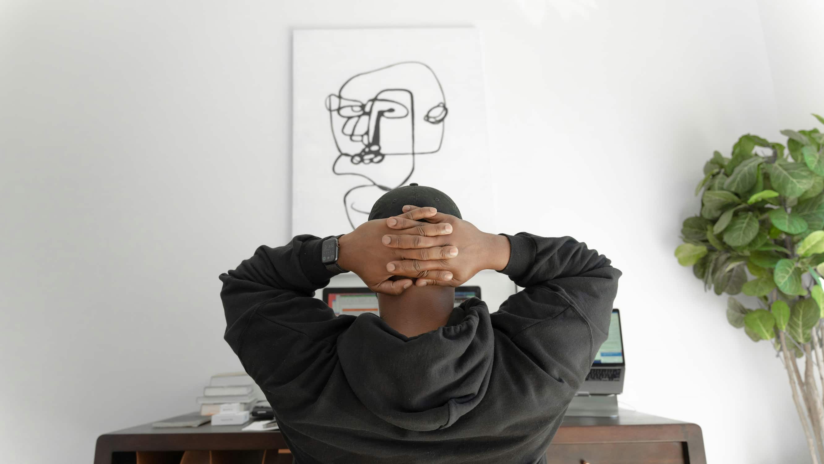 man with gray hoodie sitting on chair